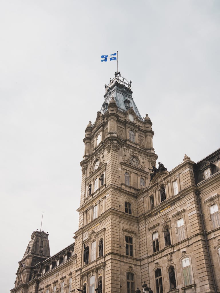 Captivating view of a historic building with a Québec flag, showcasing architectural splendor in Québec City, Canada.