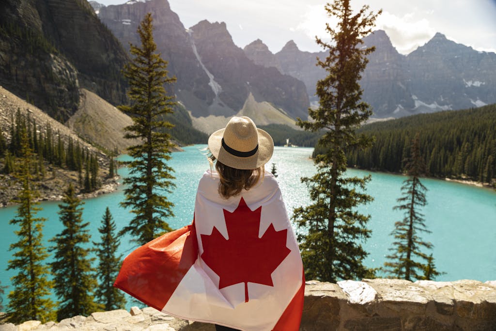 Explore the beauty of Moraine Lake in Alberta, Canada, with a stunning view and a Canadian flag.