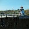 Picturesque scene of a riverside lighthouse with a boardwalk, perfect for travel and outdoor themes.