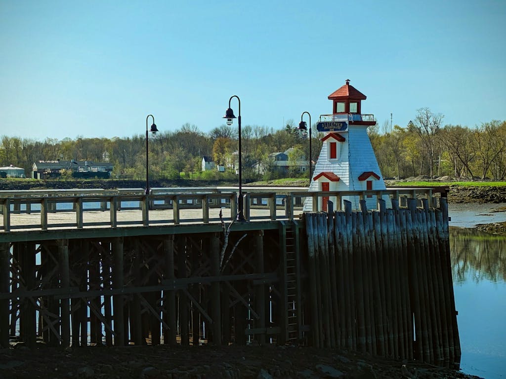 Picturesque scene of a riverside lighthouse with a boardwalk, perfect for travel and outdoor themes.